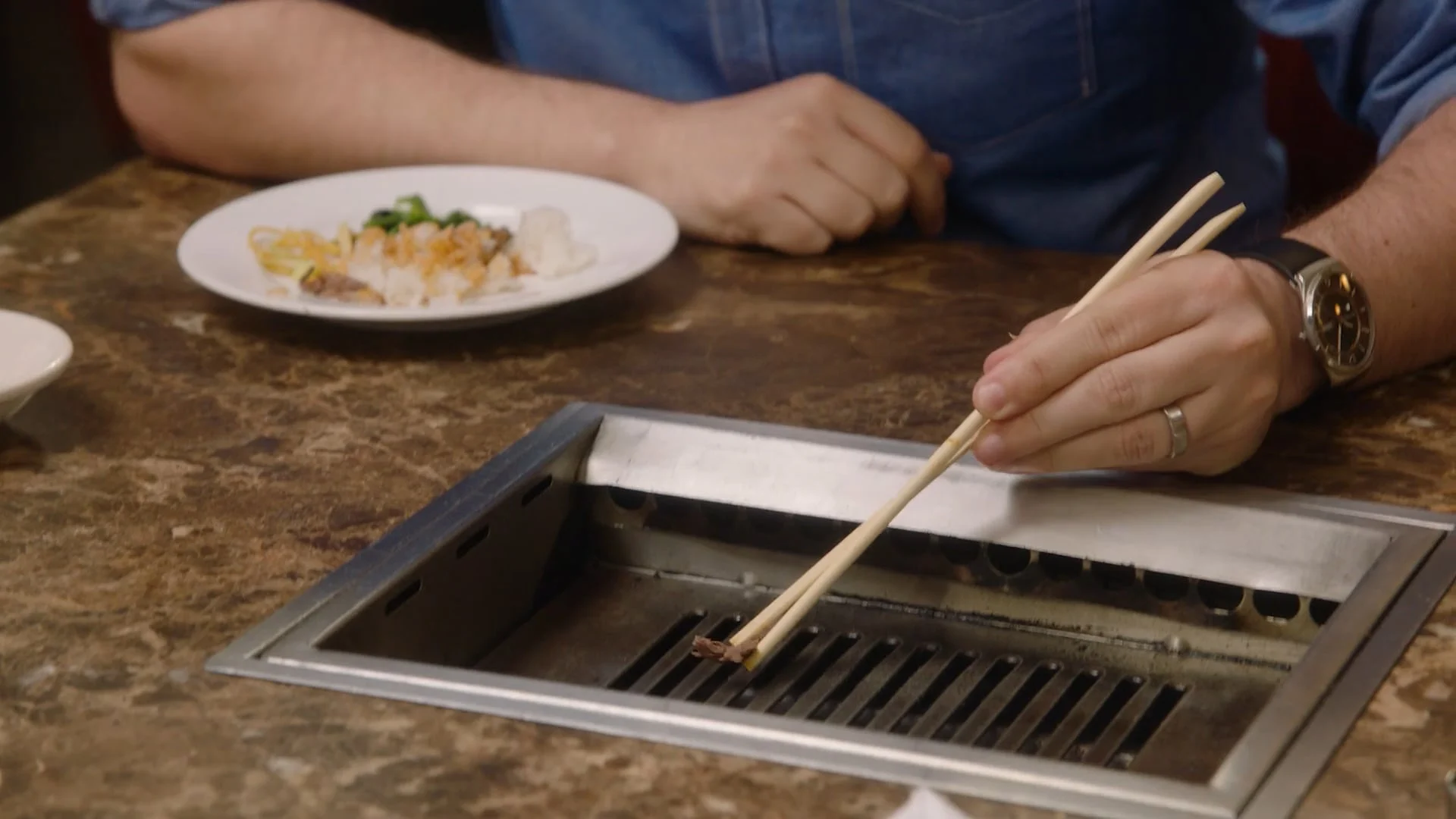 Chopsticks over a tabletop grill
