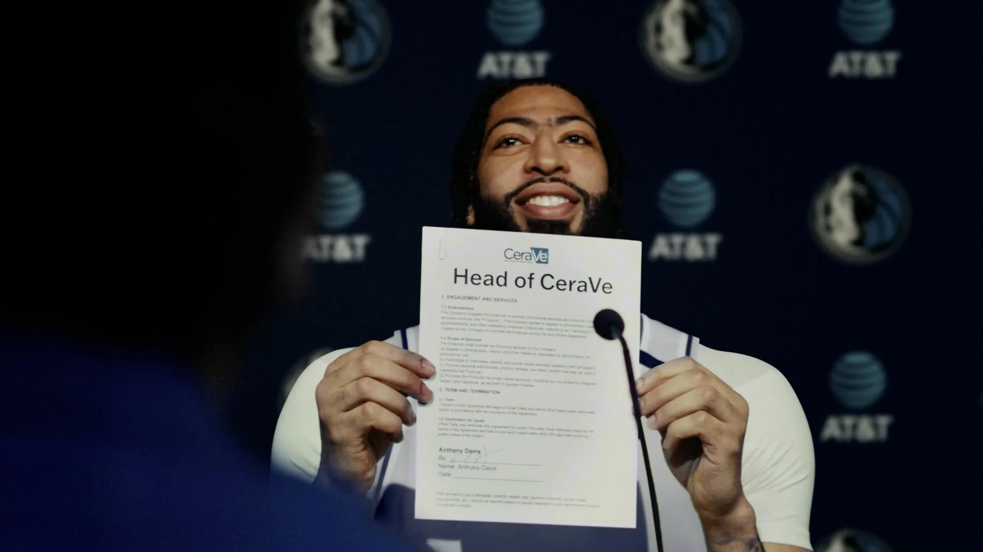 An athlete at a press conference holding a Head of CeraVe offer letter